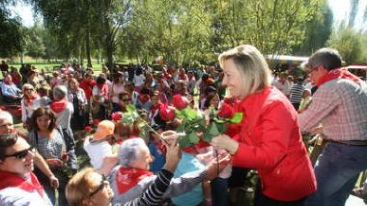 Amparo Valcarce y Francisco Fernández entregan rosas a los simpatizantes y militantes.