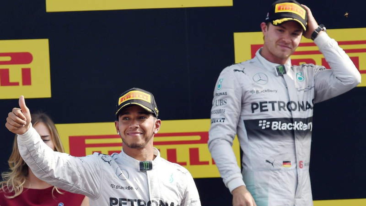 Hamilton celebra su victoria en Monza bajo la mirada de su compañero Rosberg.