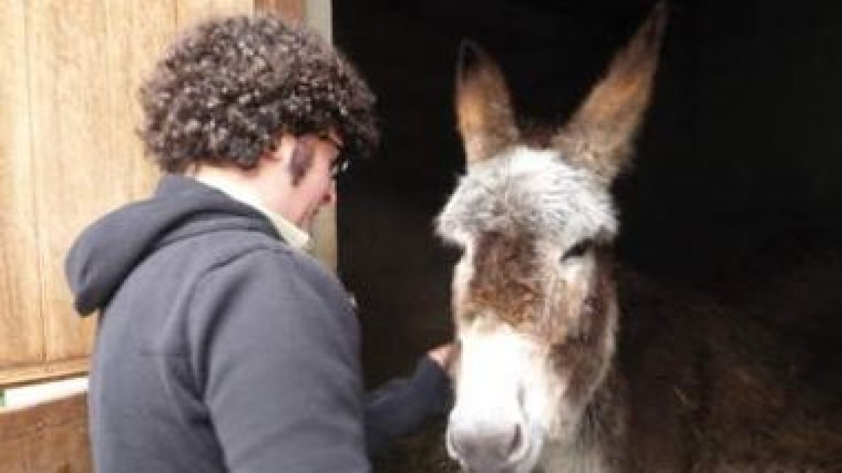 Ricardo Pérez Palacios, en la granja de Cando, con uno de los animales con los que vive y convive.