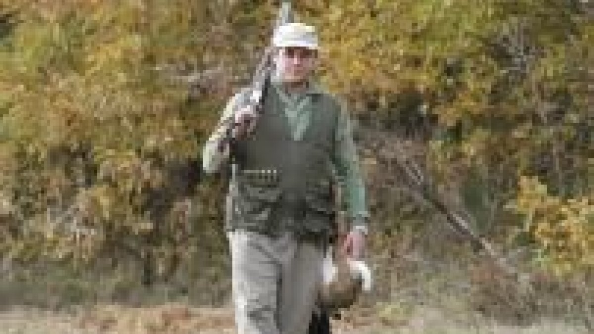 Un joven cazador cuelga una liebre en una foto de la primera jornada de caza de la temporada en León