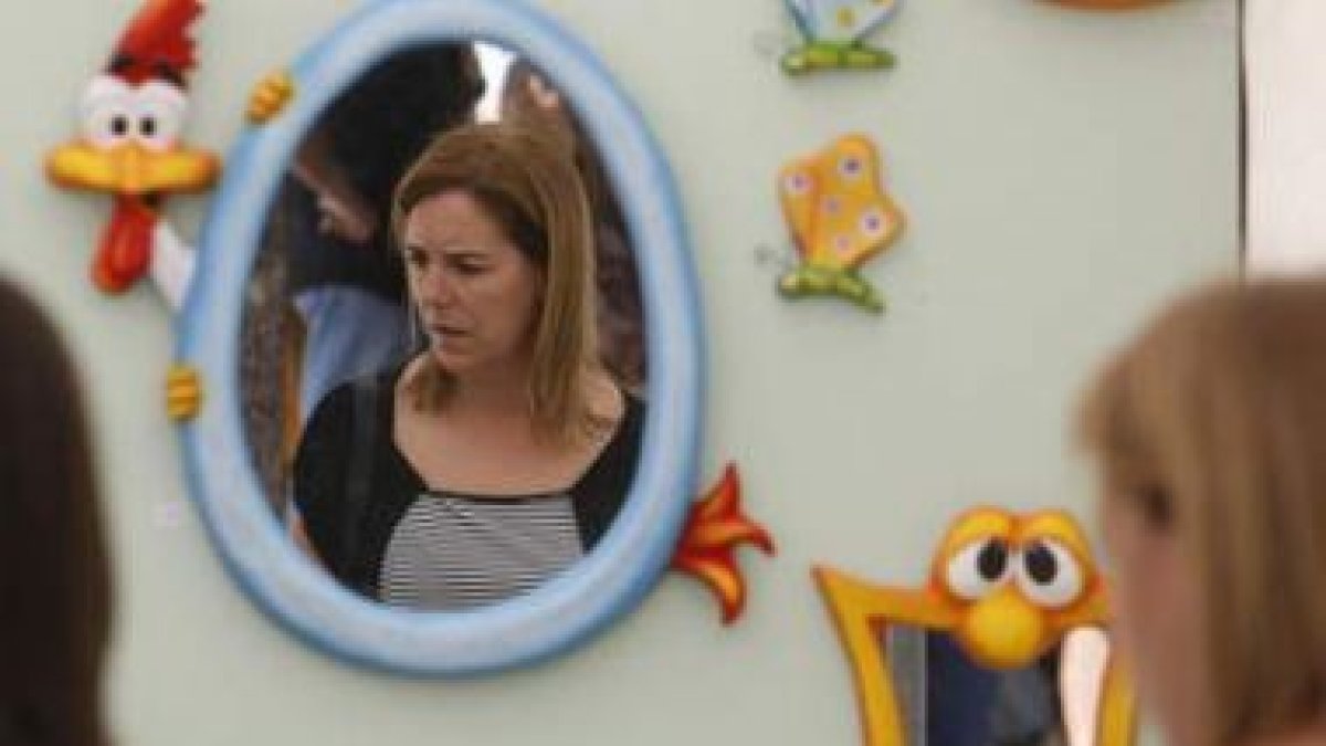 Una mujer contempla uno de los puestos de artesania de la feria de Astorga.