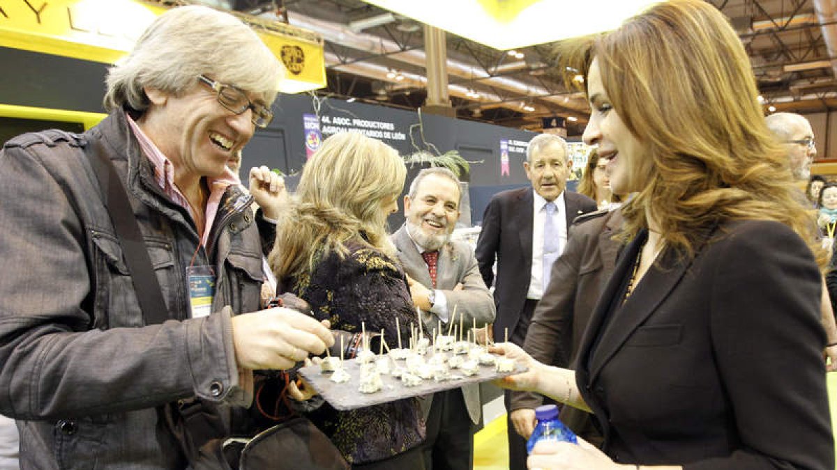 La consejera de Agricultura, Silvia Clemente, ofrece queso de León a los periodistas que cubren la feria.