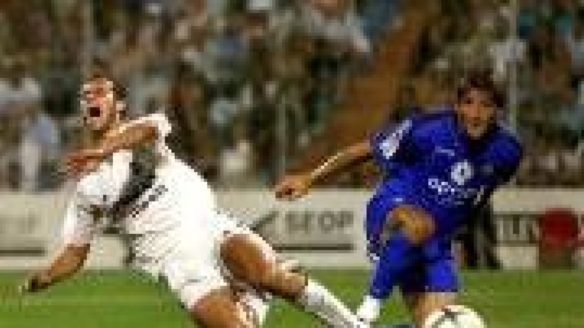 El madridista Iván Helguera cae al suelo quejándose ante la entrada del jugador del Getafe Yordi