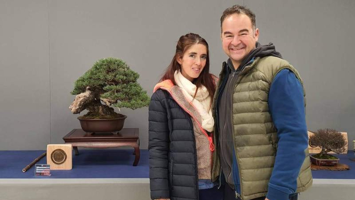 El leonés Rubén Ciezar posa con su mujer, Lorena Vilas, junto al pino salvaje ganador. DL