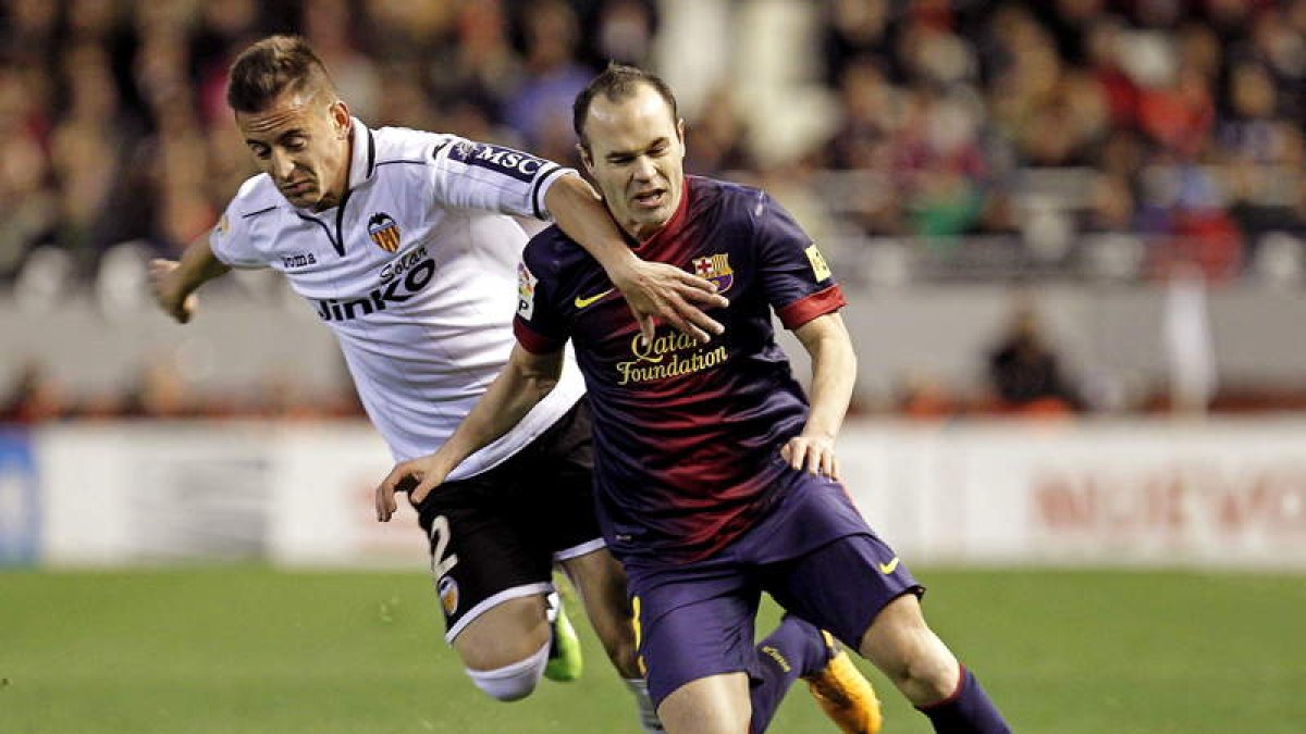 Andrés Iniesta pelea un balón con el defensa portugués del Valencia Joao Pereira.