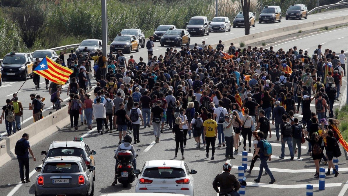 Centenares de personas se dirigen caminando por la Ronda Litoral de Barcelona al Aeropuerto de El Prat. TONI ALBIR.