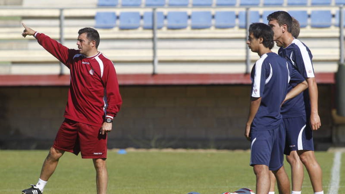 Cembranos, a la izquierda, dando instrucciones a sus jugadores en el entrenamiento de ayer.