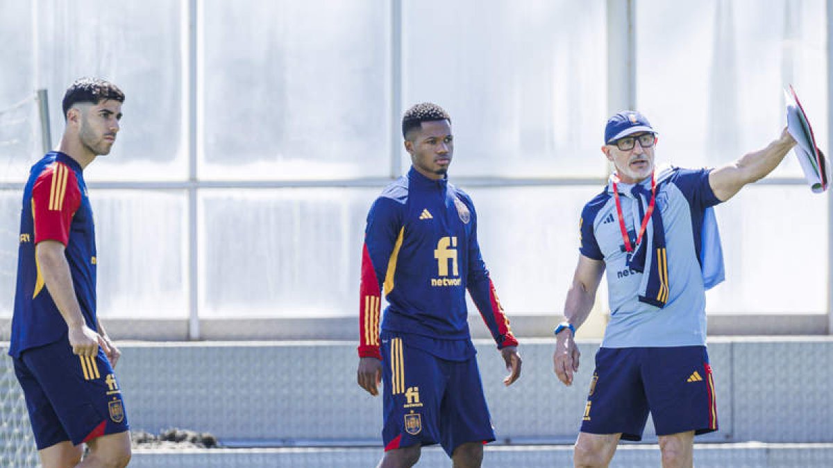 De la Fuente explica una jugada a Ansu Fati y Asensio. PABLO GARCÍA
