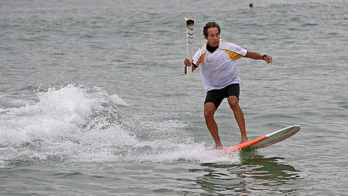 La antorcha olímpica surfea en las playas de Río.