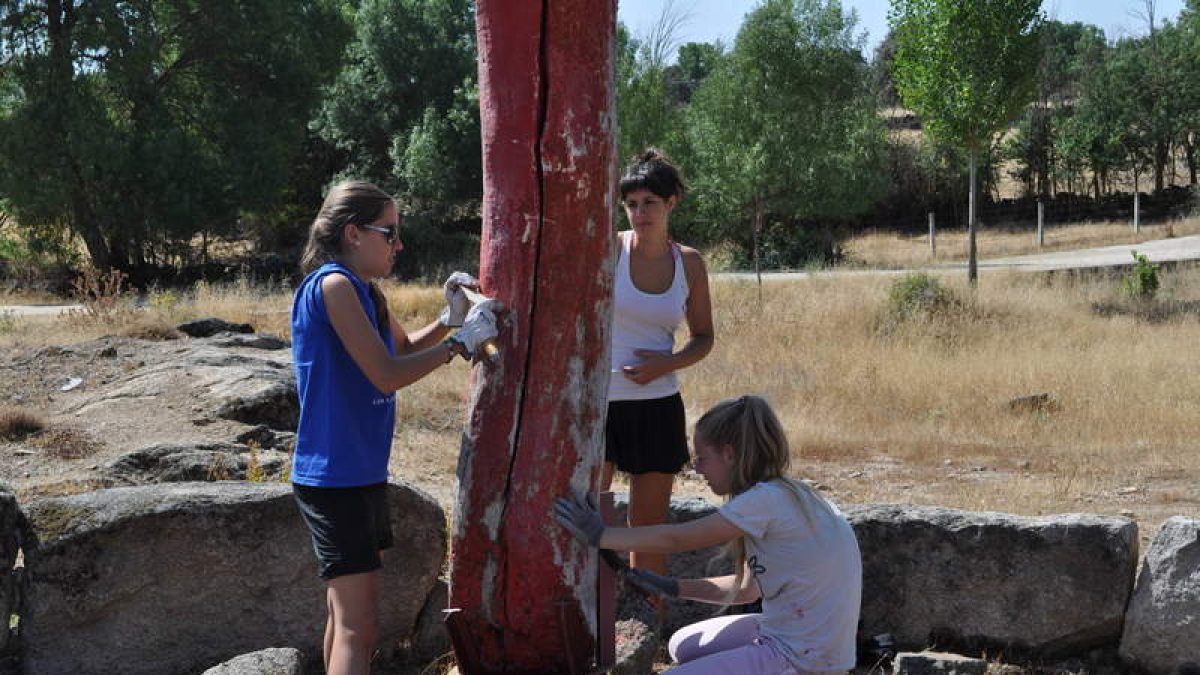 Tres jóvenes trabajan en el campo de trabajo de Monleras.