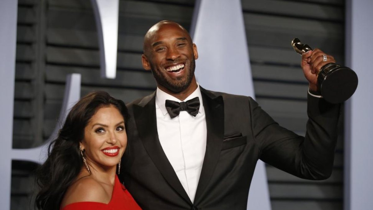 Kobe Byrant, junto a su mujer Vanessa, sostiene el Oscar a la entrada de la fiesta de Vanity Fair