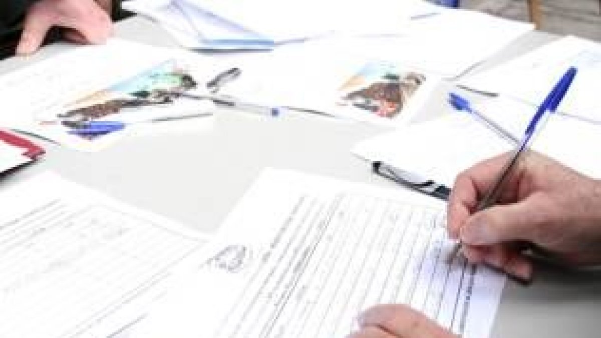 Un ciudadano estampa su firma en una de las mesas de recogida