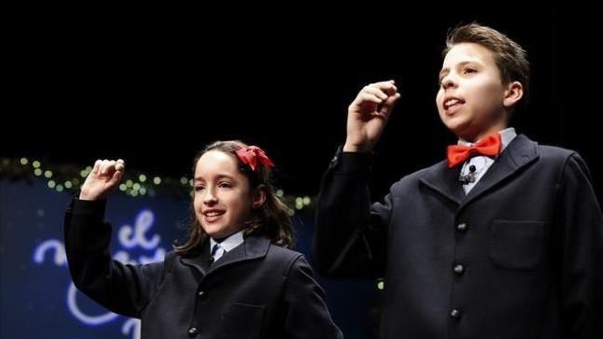 Los ninos cantores de San Ildefonso muestran las bolas con el segundo premio del sorteo extraordinario de la loteria de Navidad.
