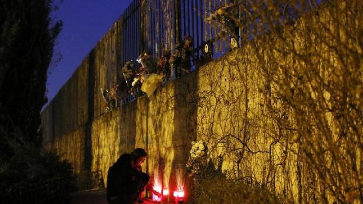 Una mujer enciende velas fuera de la estación de Atocha de Madrid en el undécimo aniversario del atentado del 11-M