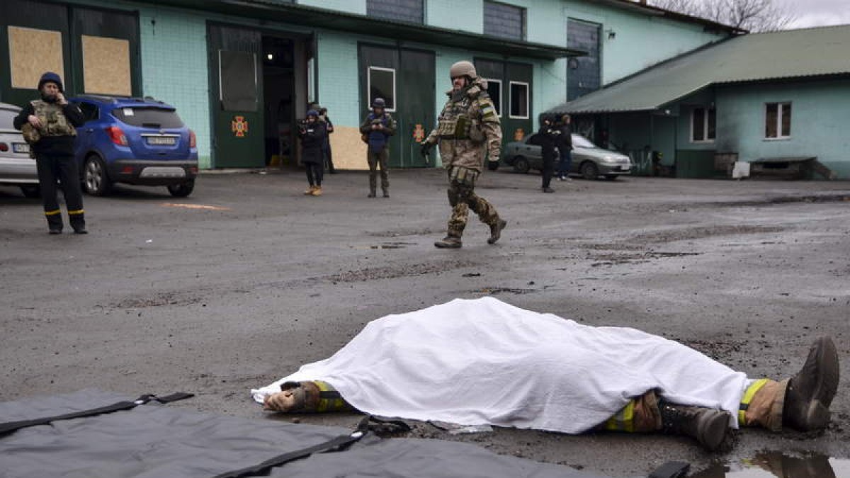 Un soldado pasa junto a un cuerpo tras el bombardeo de una estación de bomberos en Kherson. IVAN ANTYPENKO