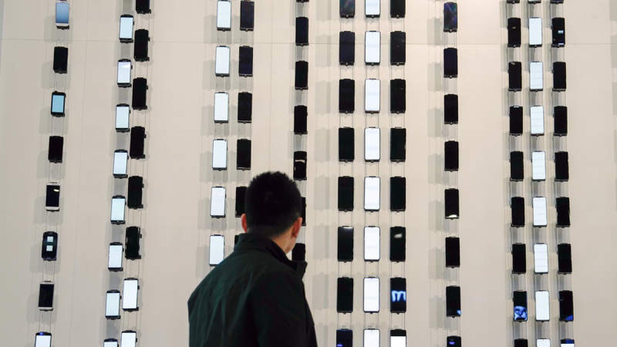 Un hombre observa un expositor de móviles. efe