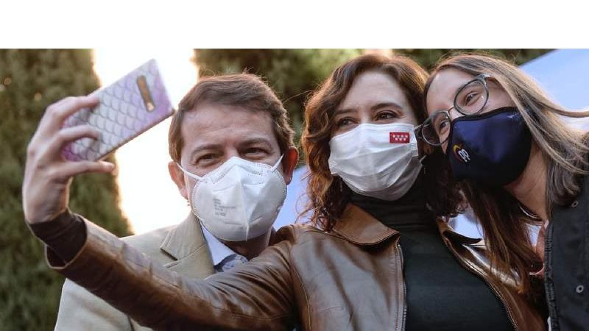 Fernández Mañueco y Ayuso se retratan con una joven simpatizante en Valladolid. EFE