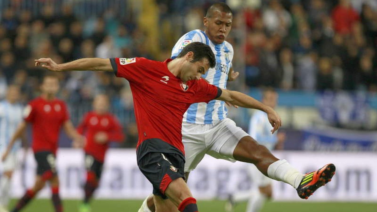 El defensa del Osasuna Miguel Flaño pelea un balón con el delantero del Málaga, Rondón.