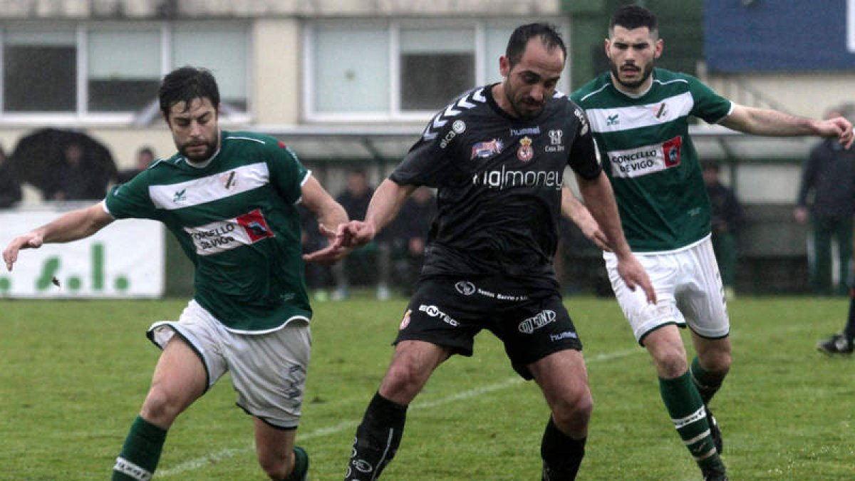 Tornero, en el centro de la imagen, controla el balón frente a dos rivales del Coruxo.