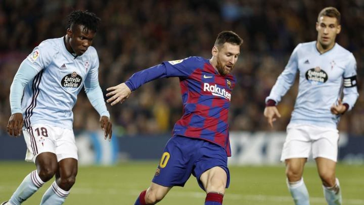 El delantero argentino del FC Barcelona, Leo Messi (c), controla el balón ante el defensa ghanés del Celta de Vigo, Joseph Aidoo, durante el encuentro correspondiente a la jornada trece de primera división que disputan esta noche en el estadio del Camp Nou, en Barcelona. EFE/Andreu Dalmau