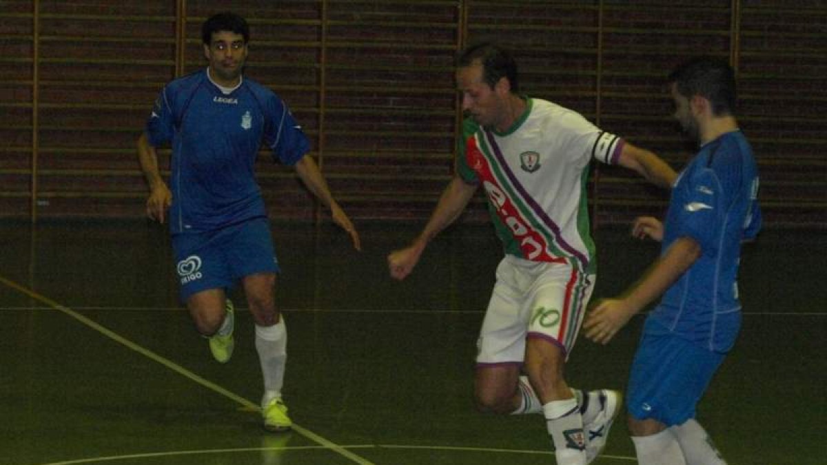Alfonso se lleva el balón entre dos jugadores gallegos.