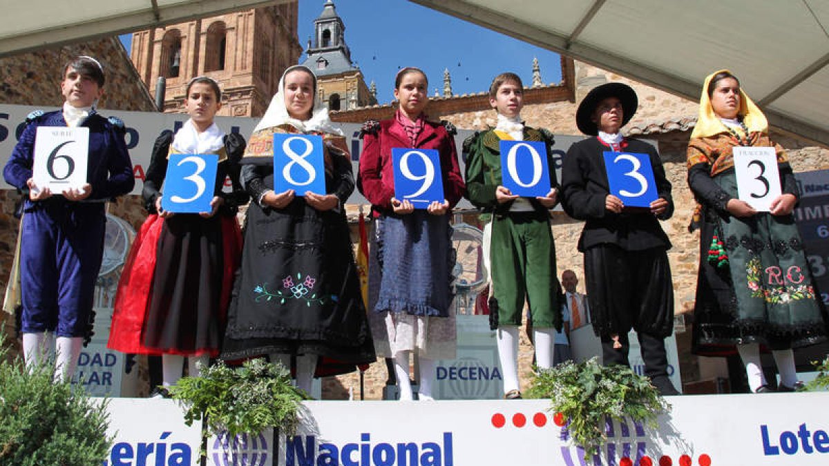 Los niños maragatos y goyescos sostienen el número agraciado con el primer premio.