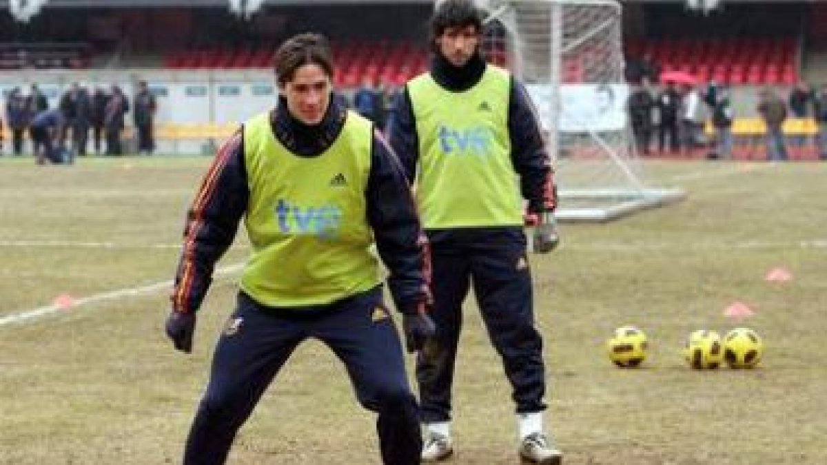 Fernando Torres y Capdevila, durante el entrenamiento de su selección sobre el maltrecho césped.