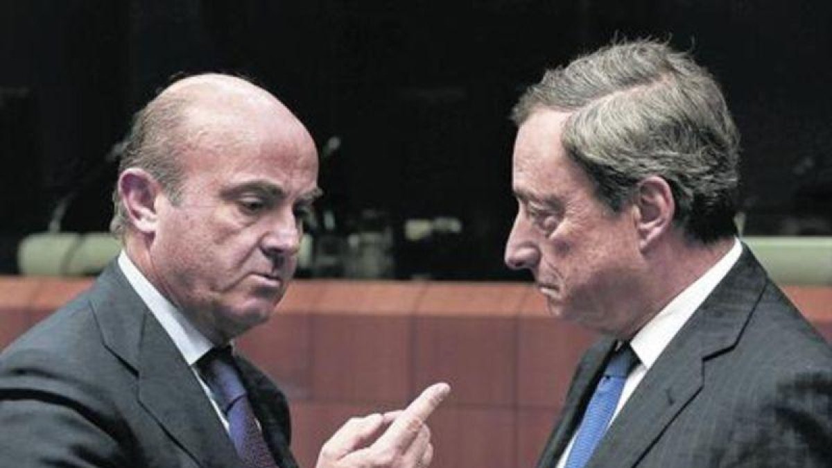 El ministro de Economía español, Luis de Guindos, y el presidente del BCE, Mario Draghi, durante una reunión del Eurogrupo.