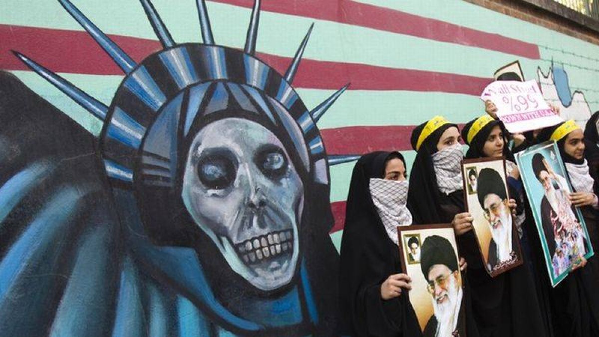 Estudiantes iranís sostienen fotos del ayatolá Jamenei ante el muro de la antigua Embajada de EEUU en Teherán, el viernes, durante los actos de celebración de la toma de la legación estadounidense, hace 32 años.