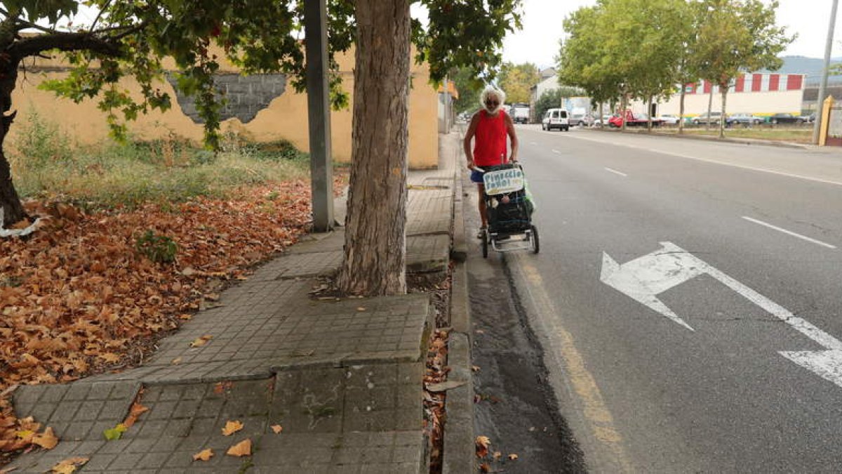 Un peregrino, ayer con su carrito, obligado a caminar por el asfalto ante las dificultades. L. DE LA MATA