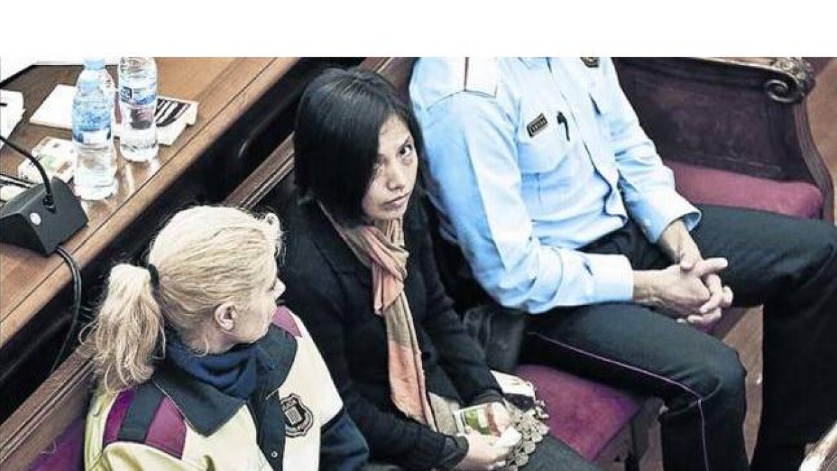 La acusada de matar a sus dos hijos, en el centro, durante la primera jornada del juicio.