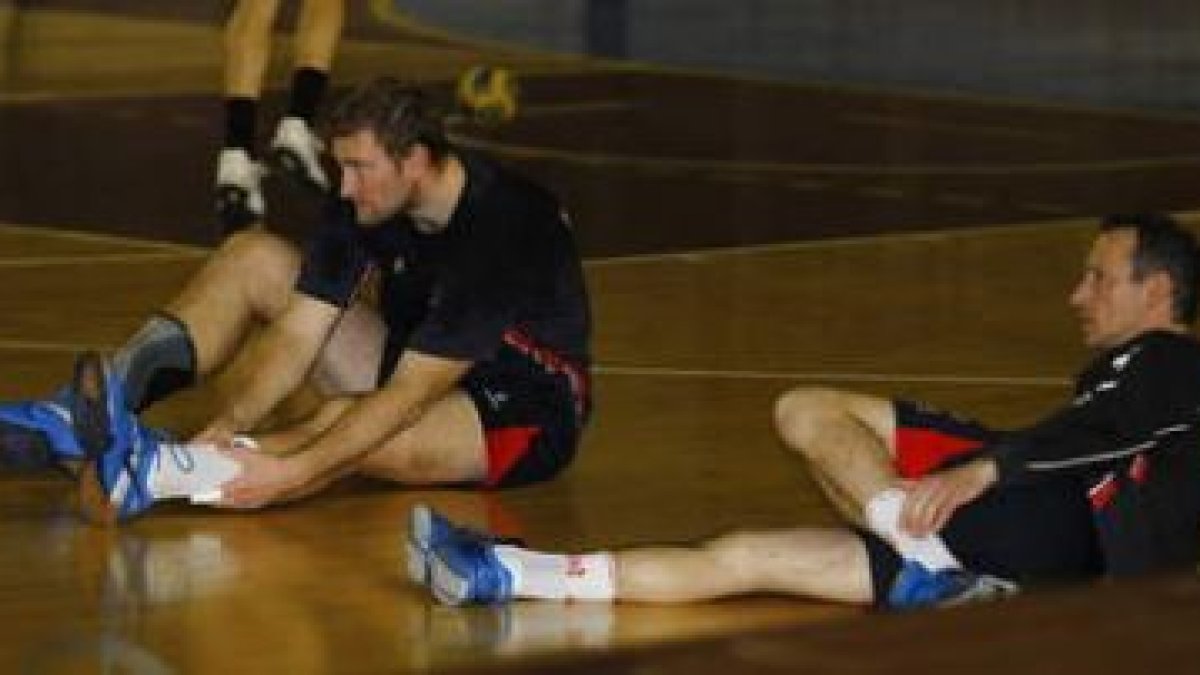 Chernov y Krivoshhlykov hacen estiramientos durante un entrenamiento con el Ademar.