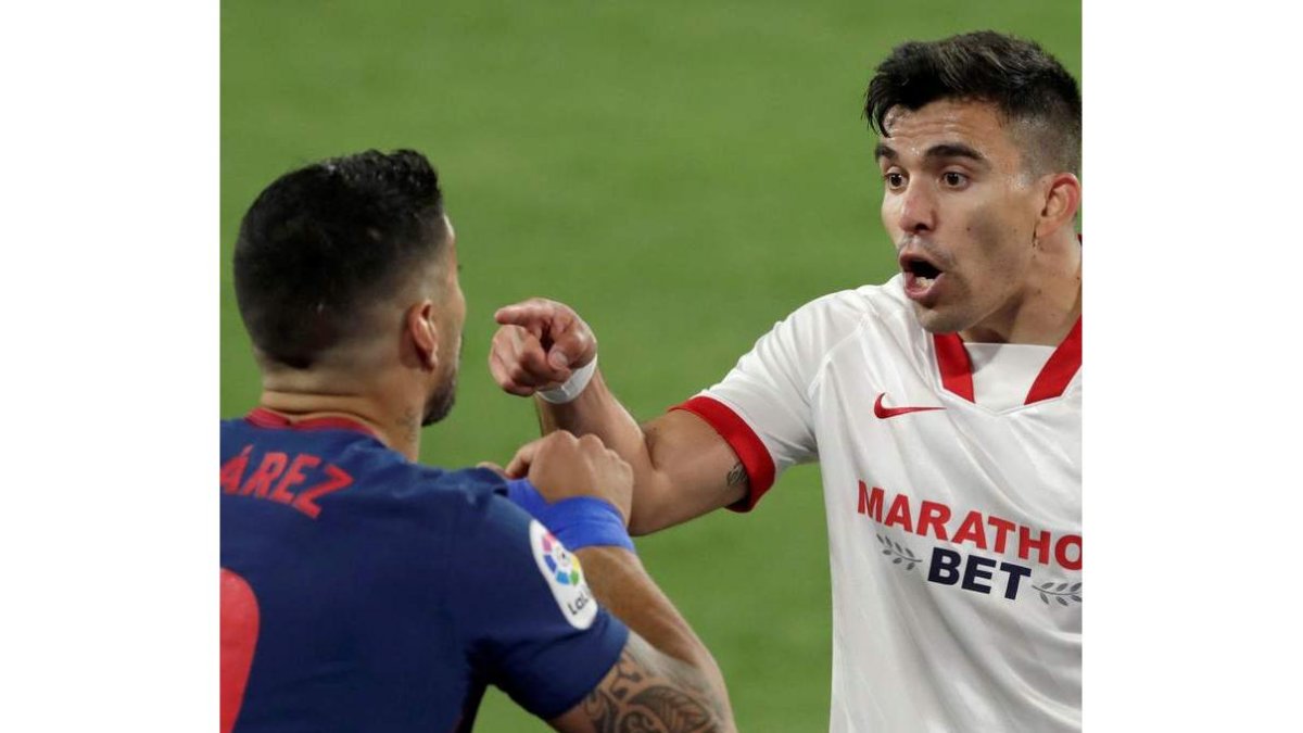 Luis Suárez y Acuña, autor del gol del Sevilla, discuten tras una acción del partido. JULIO MUÑOZ