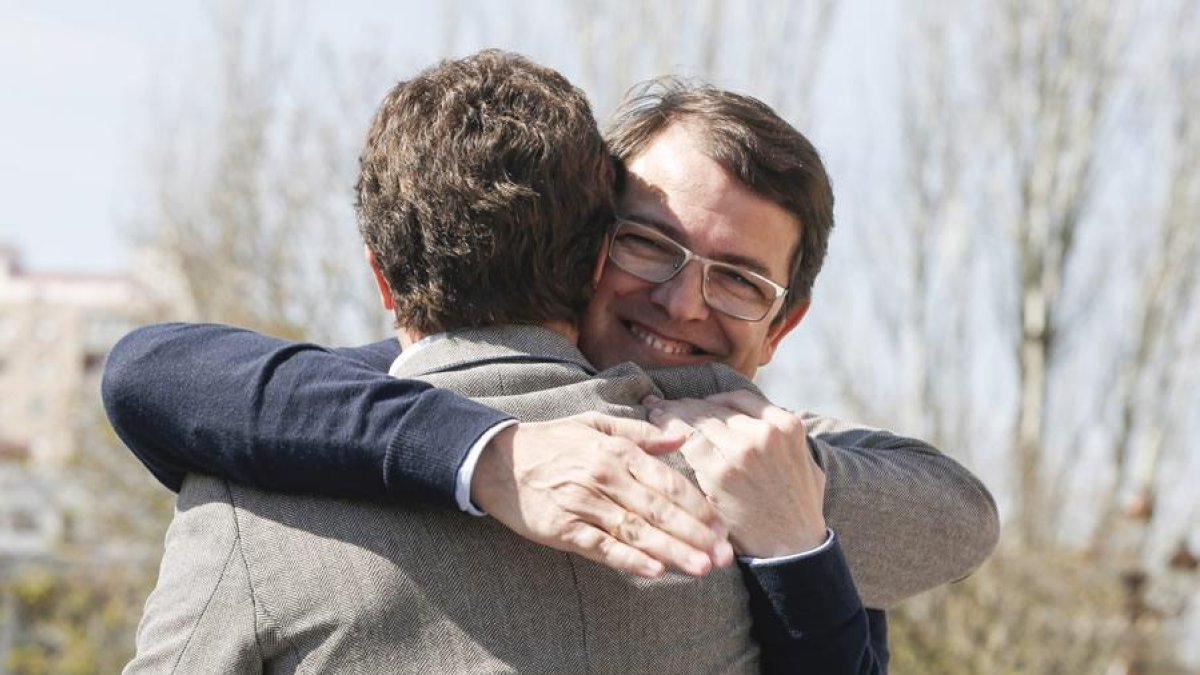 El presidente nacional del Partido Popular, Pablo Casado abraza al presidente autonómico Alfonso Fernández Mañueco tras su intervención en un acto público del partido en León.