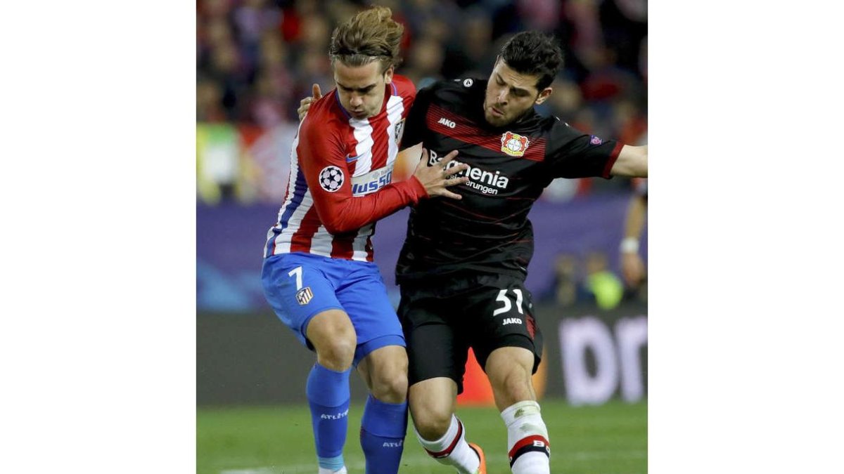 El delantero francés del Atlético, Antoine Griezmann, lucha el balón con Kevin Volland. JUANJO MARTÍN