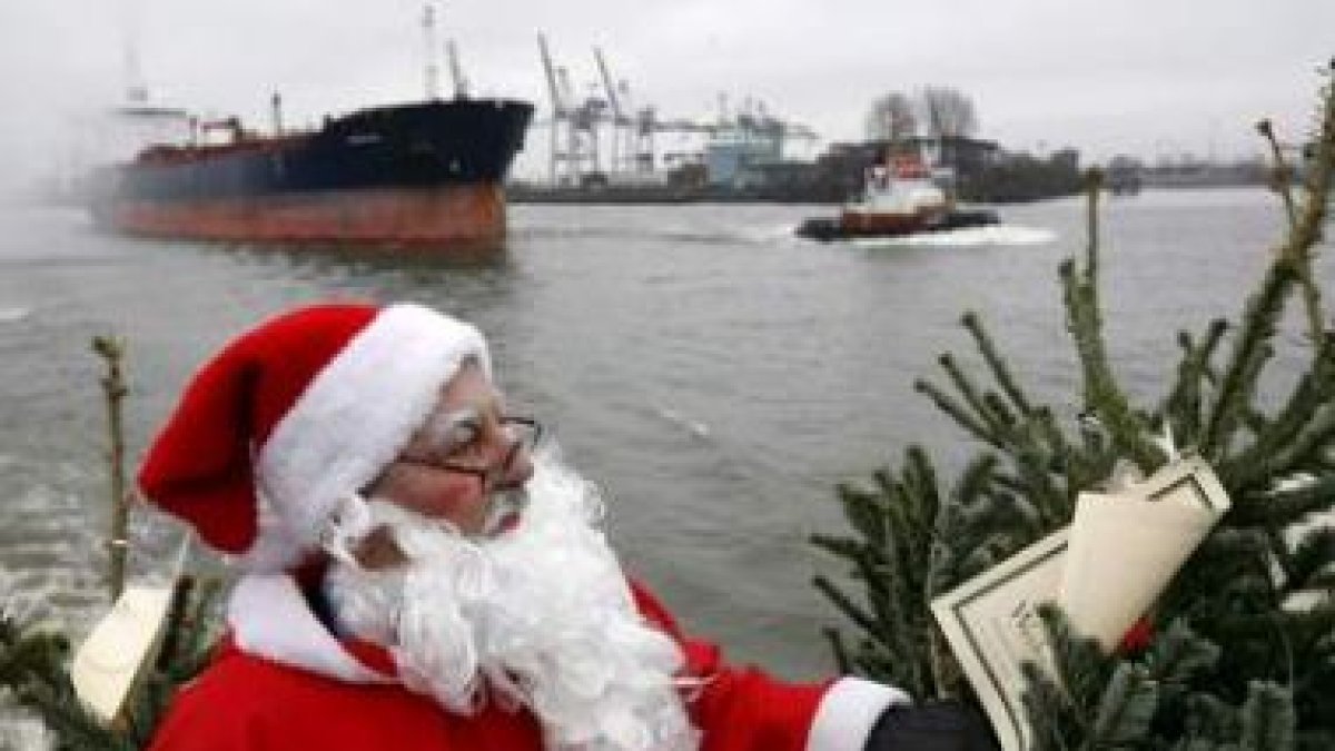 Un hombre vestido de Santa Claus observa el precio de un árbol de Navidad, uno de los gastos asumido