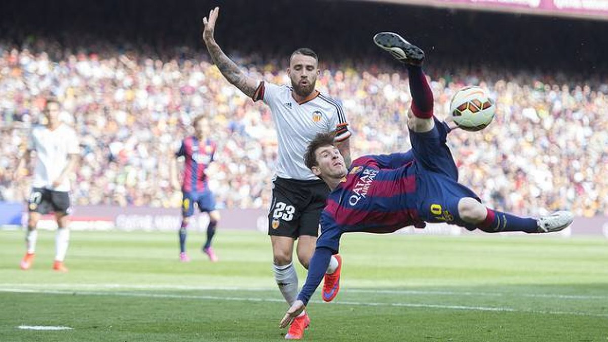 Messi chuta acrobáticamente ante Otamendi, durante el Barcelona-Valencia en el Camp Nou.