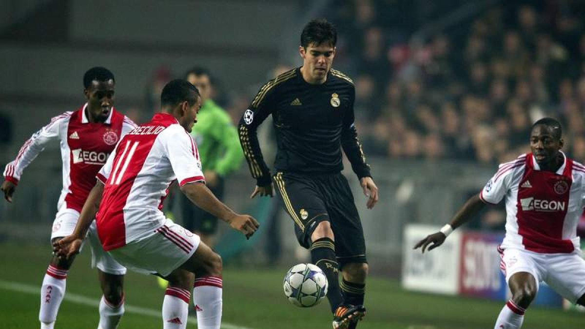 El internacional brasileño del Madrid, Kaká, rodeado de contrarios intenta controlar un balón.