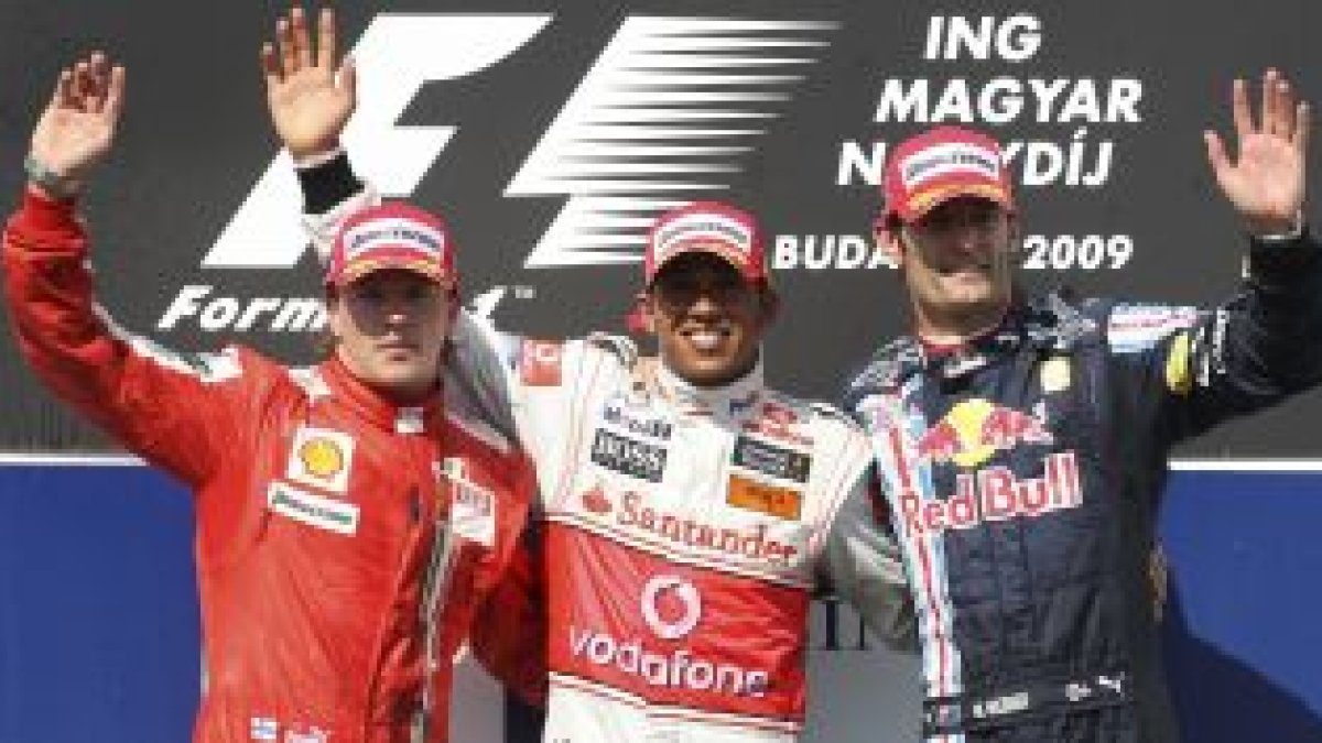 El podio, completado por Raikonen (i) y Webber (d), segundo y tercero respectivamente.