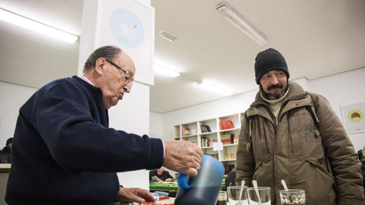 Un indigente recibe alimento de un voluntario de un comedor social. F. OTERO PERANDONES