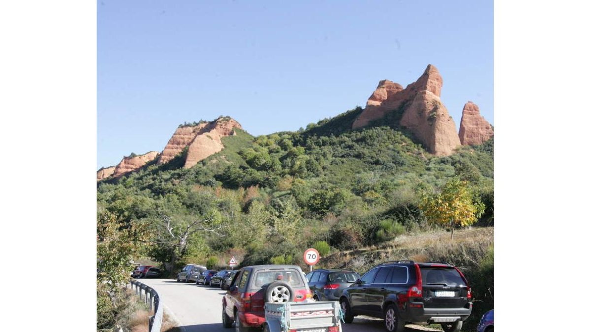 Los coches aparcaban en el arcen del acceso a Las Médulas el pasado domingo. L. DE LA MATA