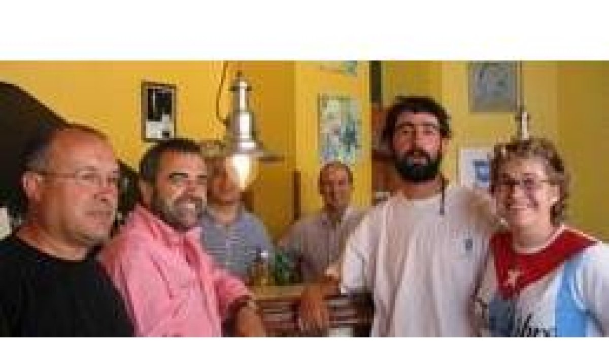 La corporación municipal posa con dos de los artistas y con varias obras al fondo