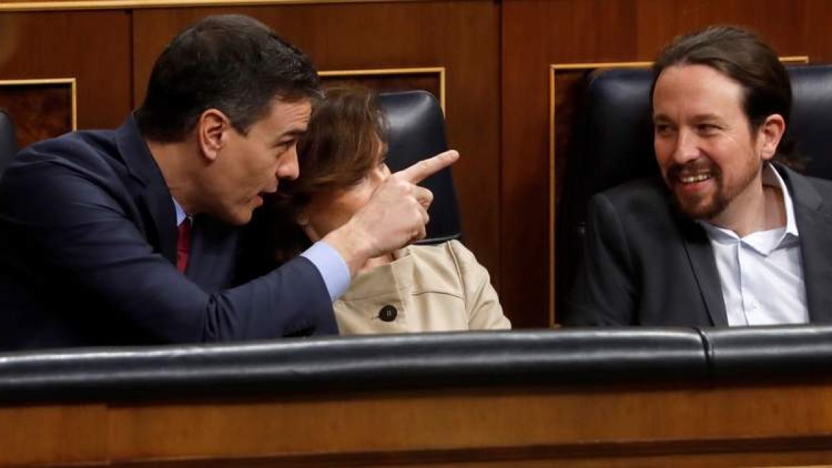 Pedro Sánchez bromea con Pablo Iglesias ante la atenta mirada de Carmen Calvo. J. J. GUILLÉN