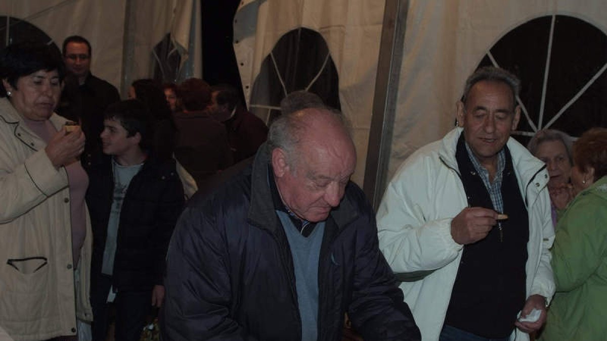 Visitantes de la feria degustan morcilla.