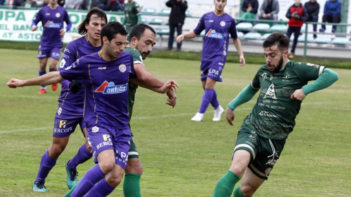 Emilio se lleva un balón a pesar de la oposición de un jugador palentino. MARCIANO PÉREZ