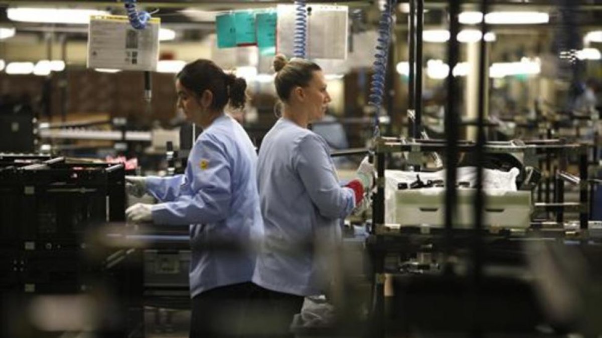 Dos trabajadoras durante su jornada laboral en la cadena de montaje de una empresa española.