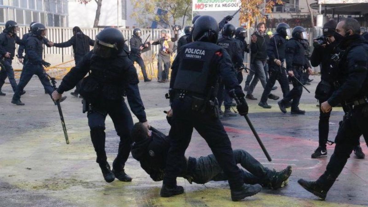Dos mossos arrastran a un manifestante en la plaza del 1 dOctubre de Girona /