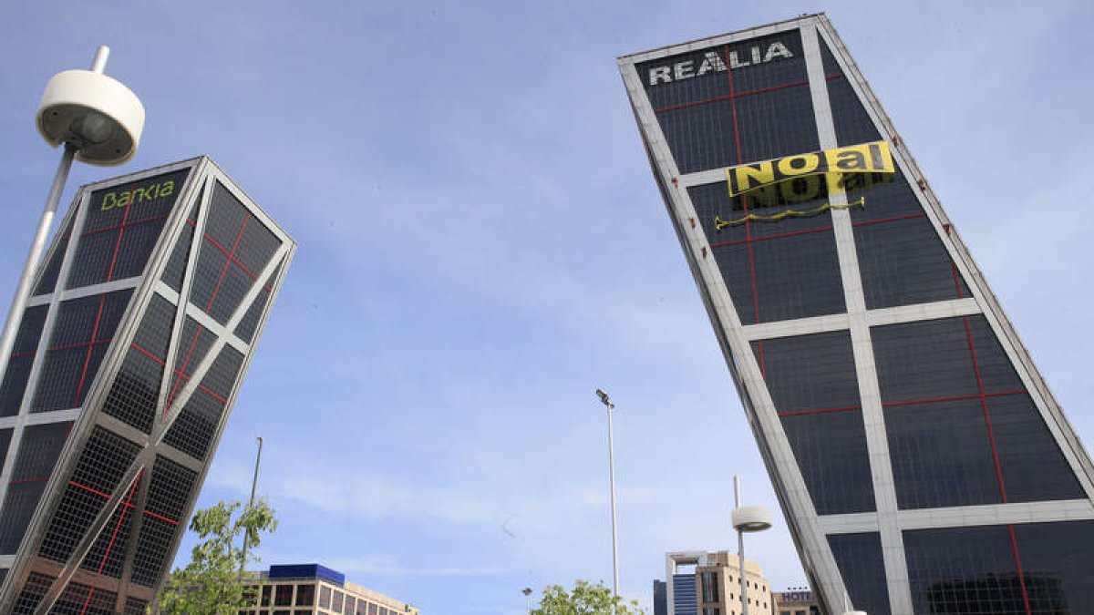 Seis activistas de Greenpeace escalaron ayer la fachada sur de una de las dos Torres Kio, en Madrid. SERGIO BARRENECHEA
