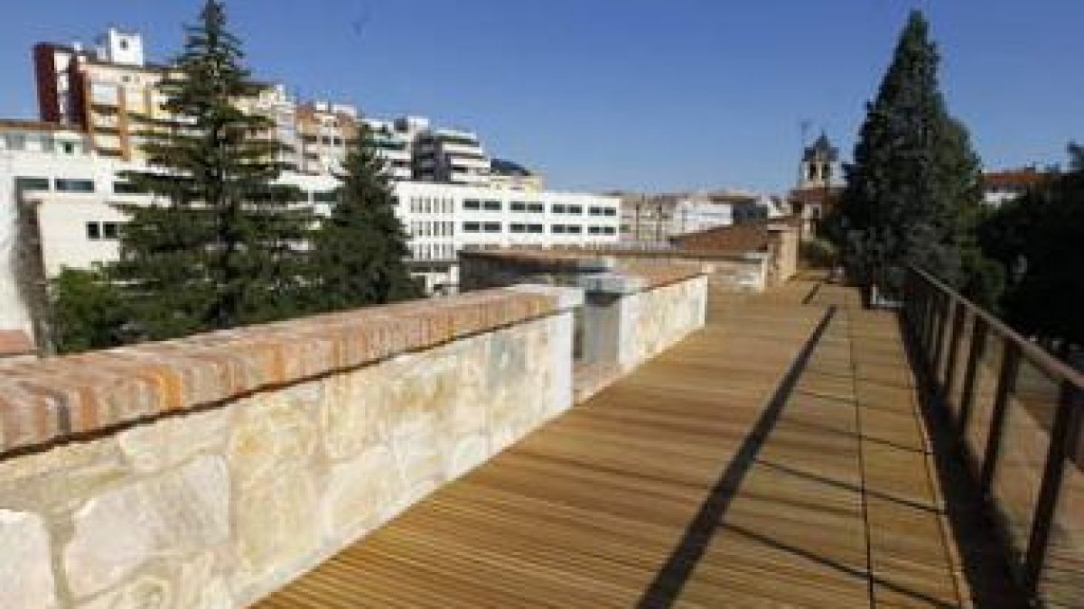 Vista del primer tramo paseable de la muralla de León, con suelo de tablillas de madera. Al fondo, l
