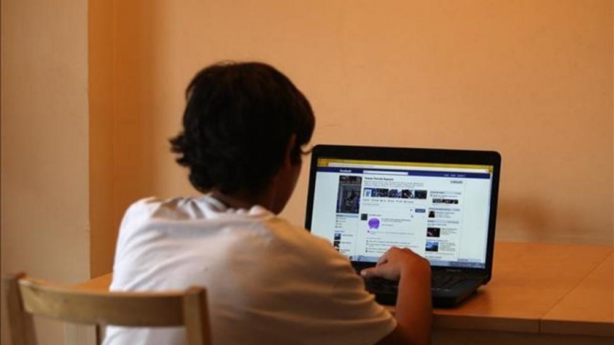 Un menor de edad mira una página de Facebook.